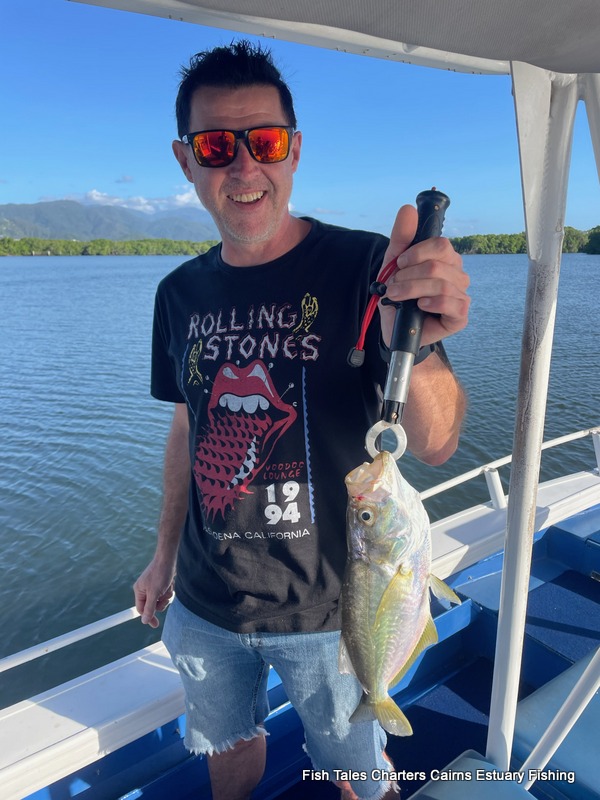 Brett is happily showing us his catch of a False Trevally while on an estuary fishing charter in Trinity Inlet, Cairns!