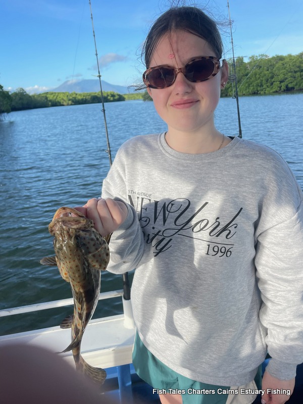 Smiles all round for Sienna and her Goldspotted Estuary Cod while on a guided estuary fishing charter is Trinity Inlet, Cairns!