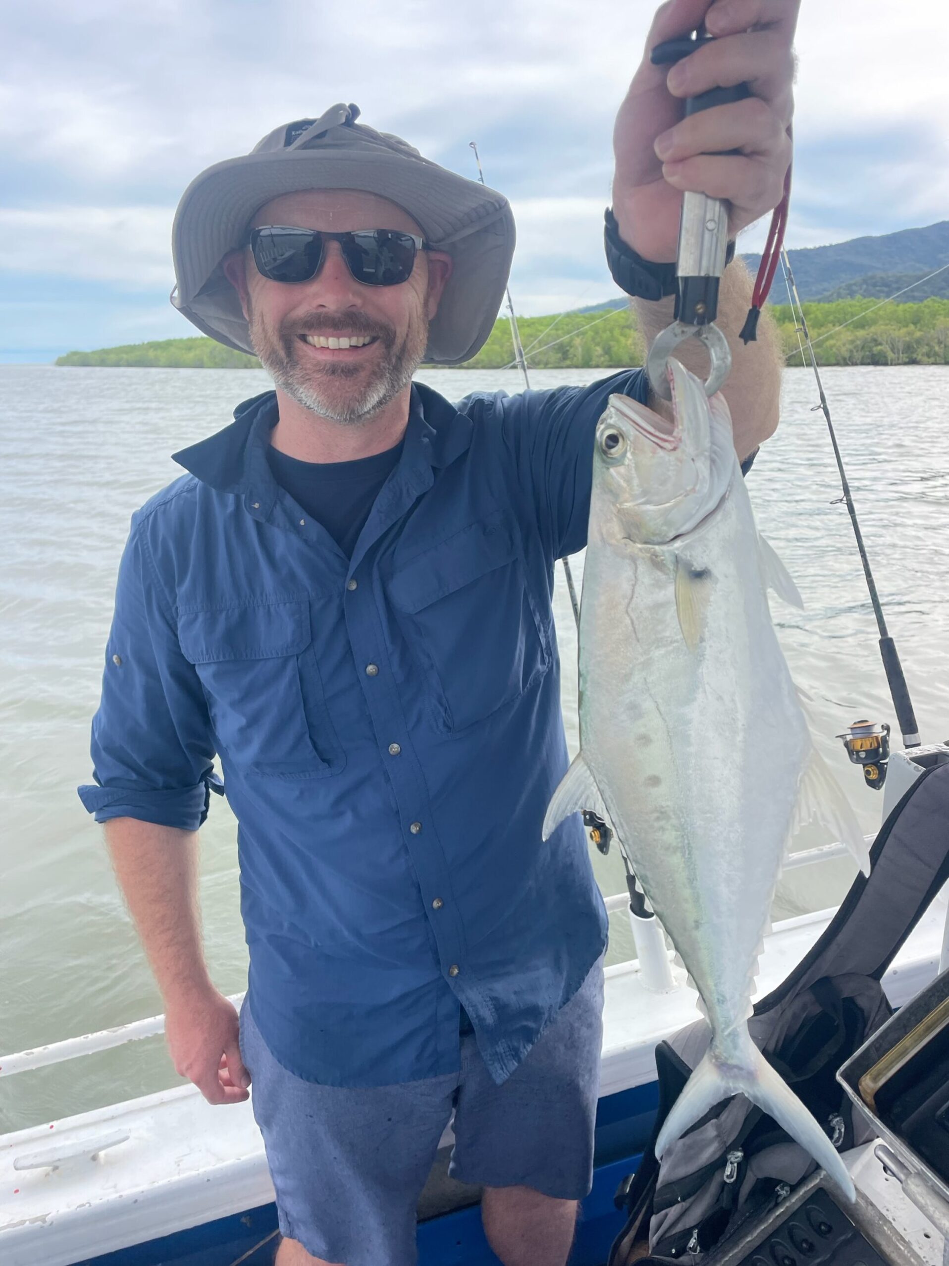 Issac showing us his catch of a Queenfish while taking a estuary fishing charter in Trinity Inlet, Cairns!